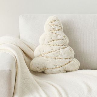 Tree Embellished Shaped Pillow on a white sofa.