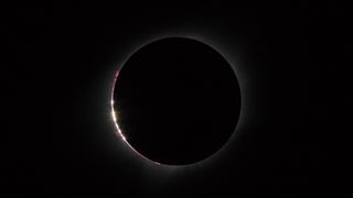 An event immediately preceding both ends of totality. Bailey's Beads is a phenomenon in which the sun's light passes through the mountains on the moon leading to the "beads" on the edge of the moon's shadow.