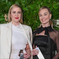 a woman (greta gerwig) in white and a woman (margot robbie) in black, both holding silver awards