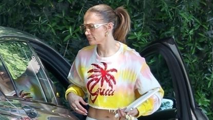 Jennifer Lopez wears a tie dye gucci top and white sweatpants while exiting her car