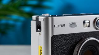 A black and gray Fujifilm Instax mini Evo hybrid instant camera