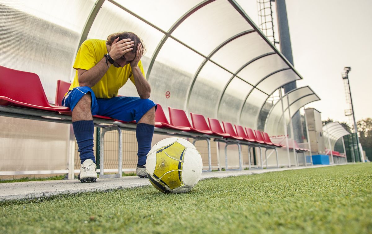 A footballer holds their head in their hands after hearing about eFootball&#039;s update delay.