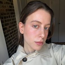 Jamie Schneider taking a selfie wearing a trench coat 