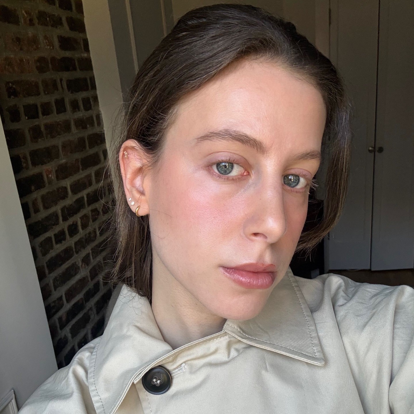 Jamie Schneider taking a selfie wearing a trench coat 