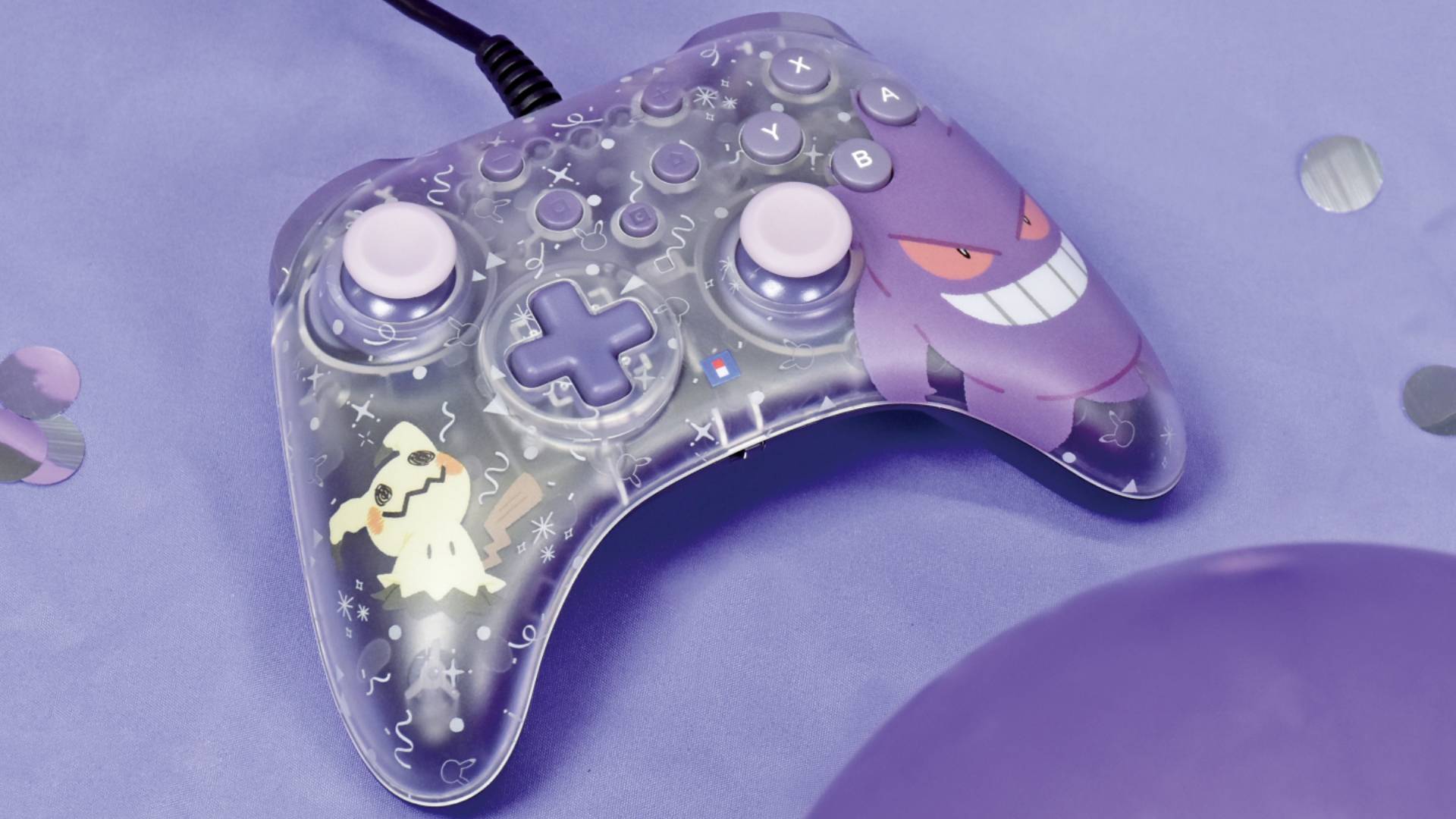 Official marketing image of a wired Hori controller with Gengar and Mimikyu on the frontplate, sitting on a purple surface.