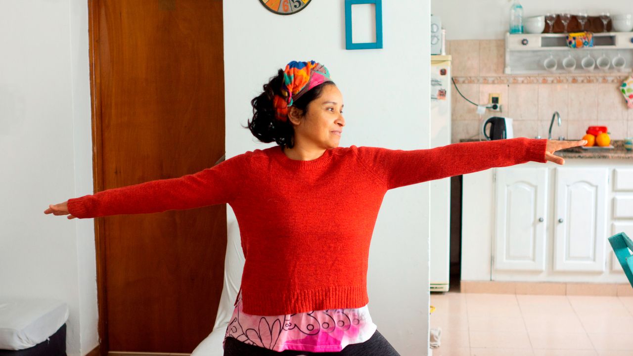 Woman holding a yoga pose in her kitchen