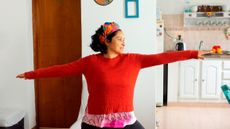 Woman holding a yoga pose in her kitchen