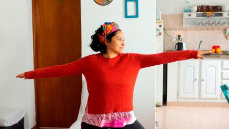 Woman holding a yoga pose in her kitchen