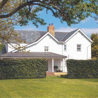 exterior of farmhouse with white render and grey slate roof