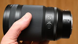 Nikon Z 35mm f/1.2 S product shot with lens held in hand