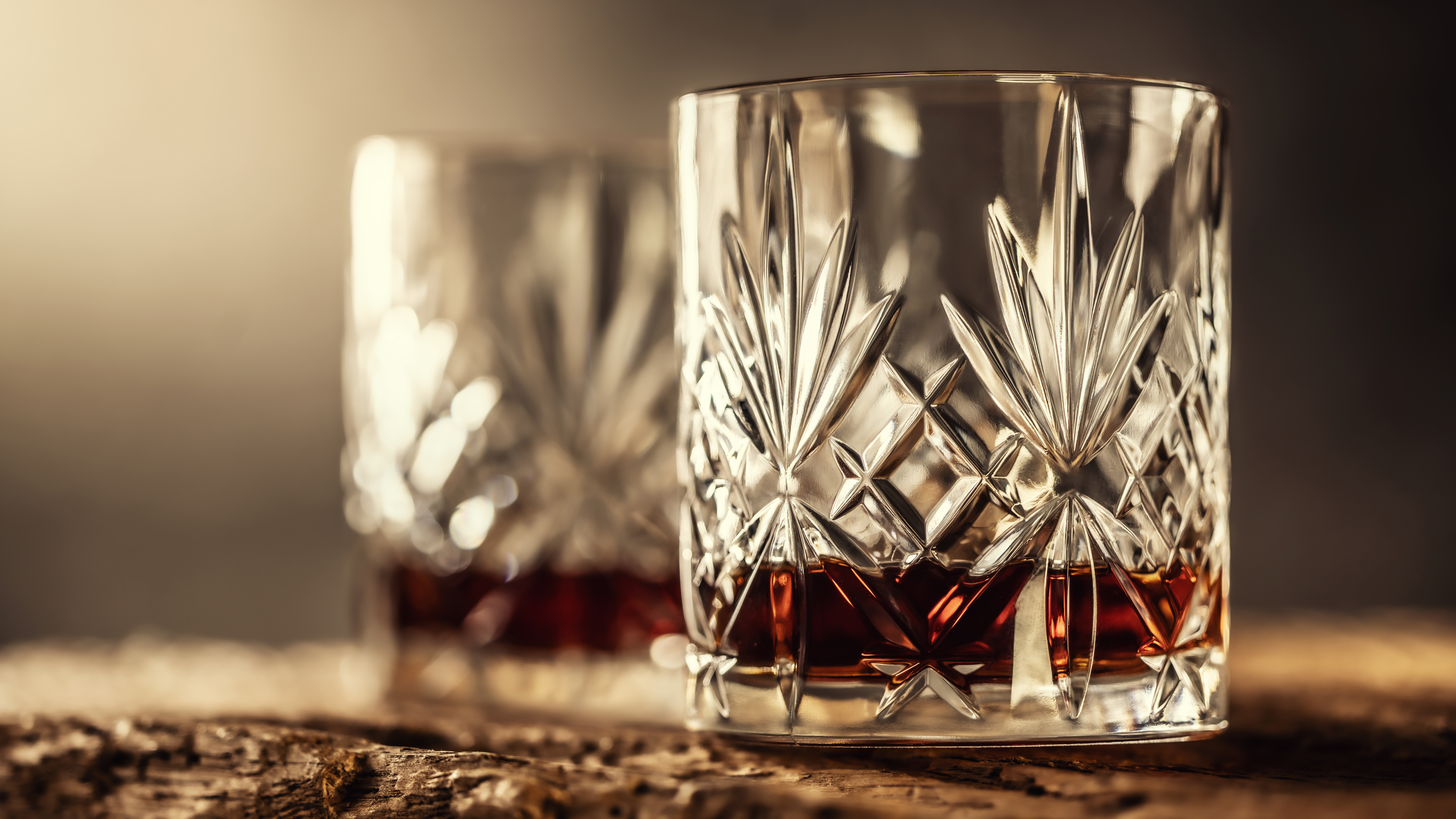 Whisky in two glasses on a wooden log