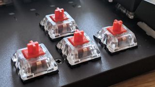 The directional keycaps have been removed to reveal the red switches of the Asus TUF Gaming K3