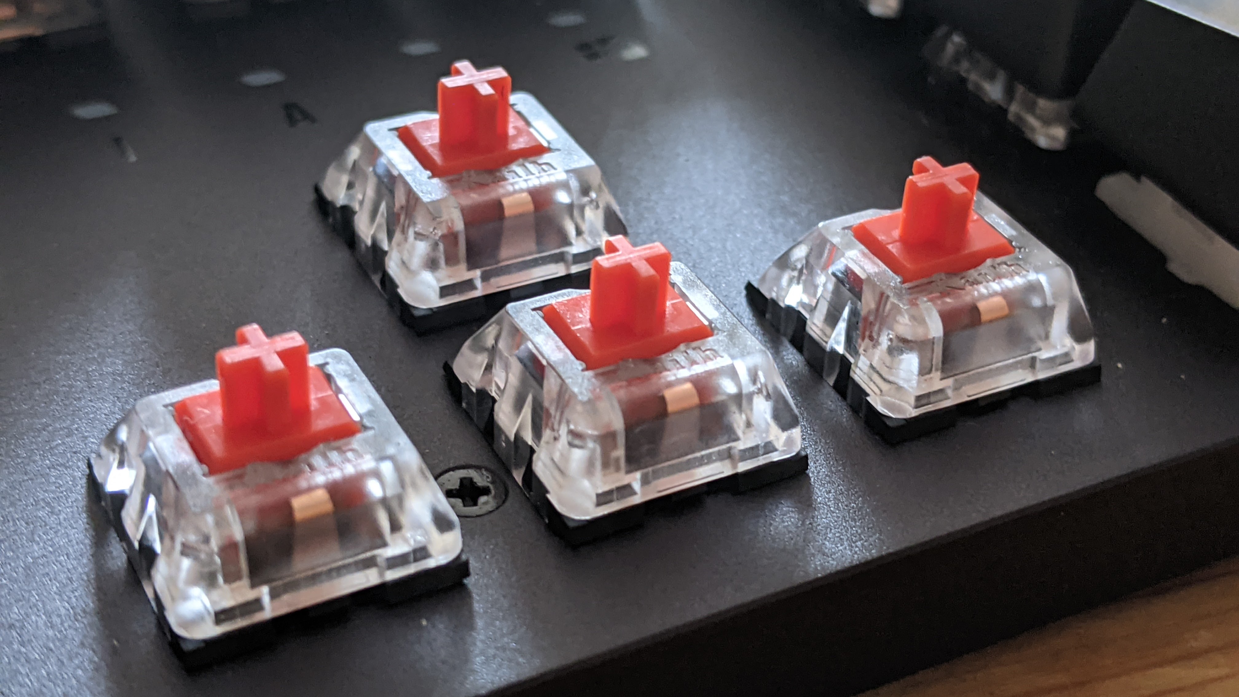 The directional keycaps have been removed to reveal the red switches of the Asus TUF Gaming K3