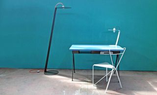 Steel desk with blue top and white steel chair and floor and table lamps