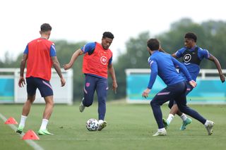 Reece James of England takes on Ben White, Ben Chilwell, and Marcus Rashford of England during an England training session at St George's Park on June 30, 2021.