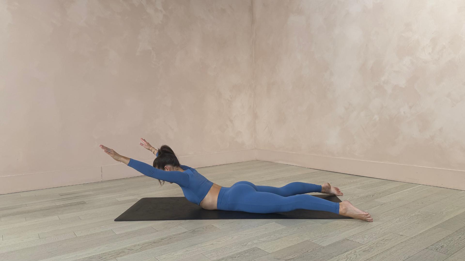 woman does back stretch on yoga mat