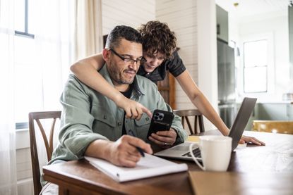 Father working from home with teenage son