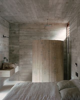 A bedroom with a concrete interior
