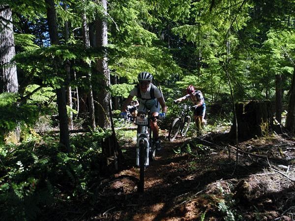 Kelly Emmett in the woods smiling and riding