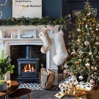 Christmas living room with log-burning fire and christmas tree.