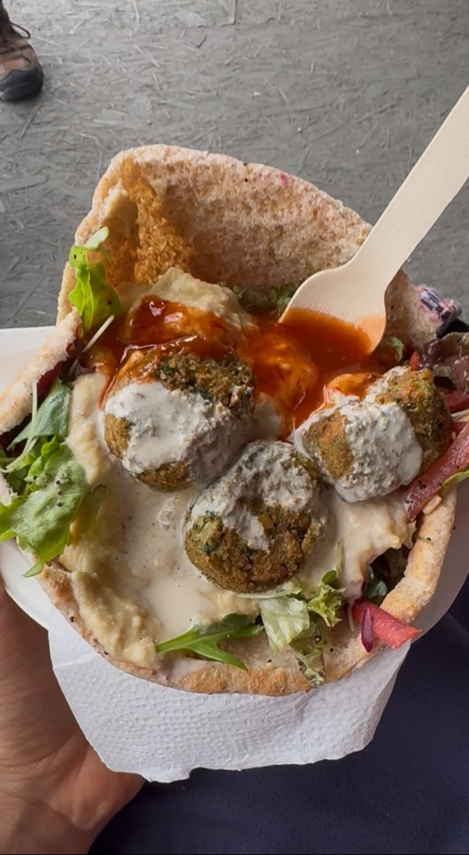 A falafel and hummus wrap, looking sloppy yet delicious