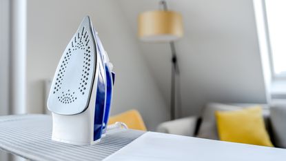 Steam iron propped up on top of ironing board