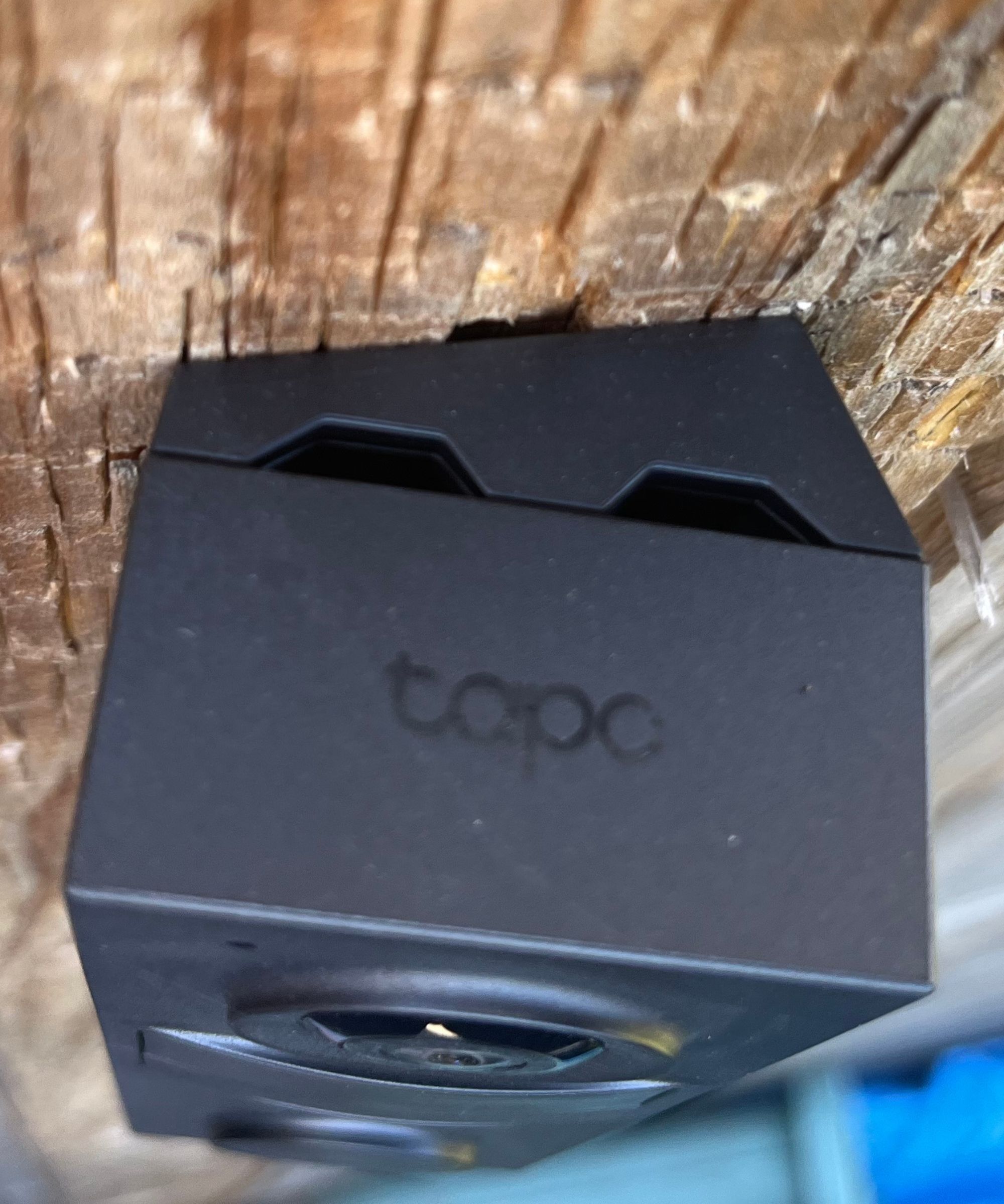 Tapo D205 Smart Video Doorbell installed on wedge on a wooden fence