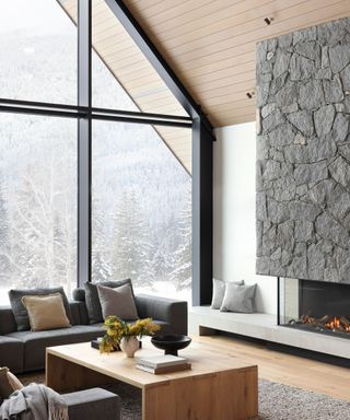 living room with stone fireplace and huge picture window onto mountains