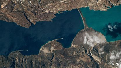 An astronaut photo showing two lakes separated by a narrow strip of land