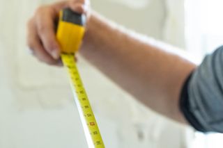 A man using a tape measure