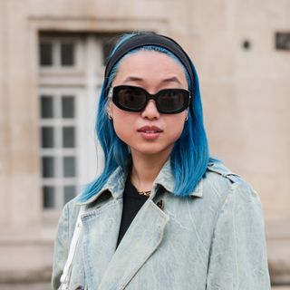 Margaret Zhang wears light blue denim long trench coat, black sunglasses, outside Balenciaga, during the Womenswear Fall/Winter 2024/2025 as part of Paris Fashion Week on March 03, 2024 in Paris, France.