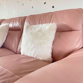 pink leather sofa with fluffy cushion and pink wall
