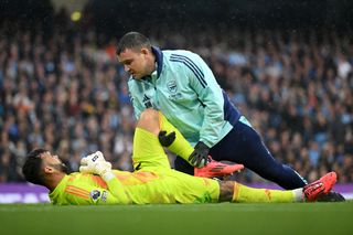 David Raya of Arsenal receives medical treatment during the Premier League match between Manchester City FC and Arsenal FC at Etihad Stadium on September 22, 2024 in Manchester, England.