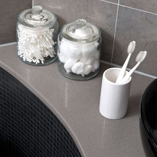 bathroom with toothbrush holder and cotton ball and cotton buds