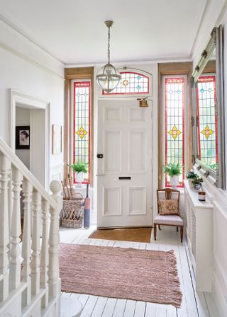 traditional-style hallway with white floor and stained glass windows round the door