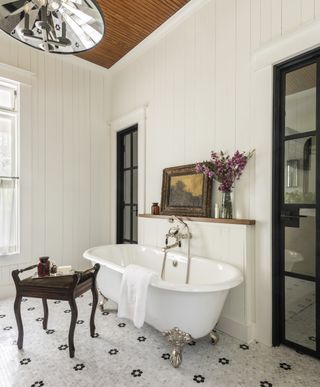 White bathroom with penny tiles and a free standing bath