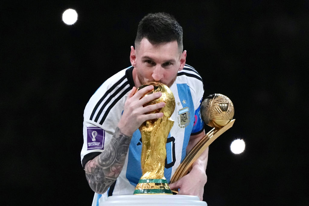 Adidas Golden Ball winner Lionel Messi of Argentina kisses the FIFA World Cup Winner's Trophy