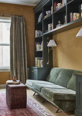 gold wall and green sofa with red carpet