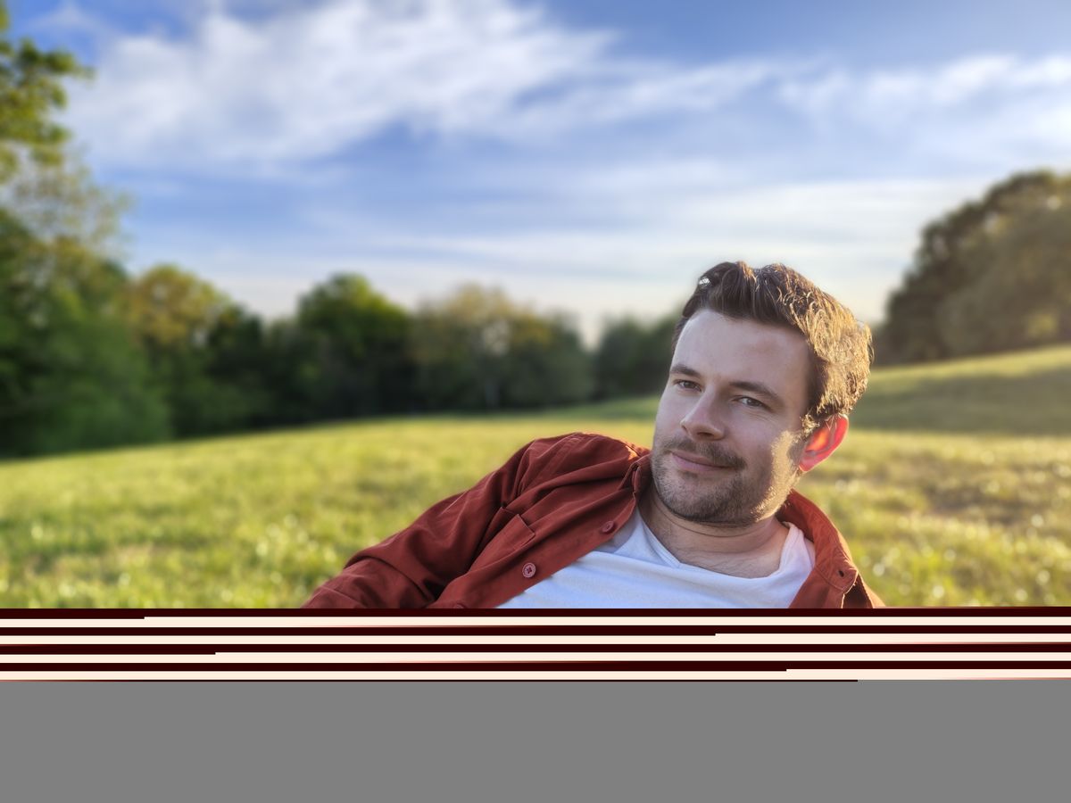 A camera sample taken on the Motorola Edge 70 Fusion, showing a man lying on a field