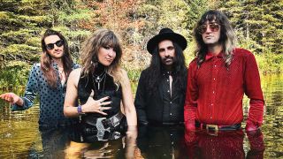 The Damn Truth standing waist deep in a lake