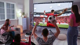 Sports fans watching a soccer game in a living room.