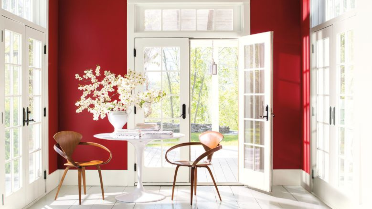 red and white conservatory with two chairs and table and white flowers