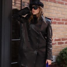 Nikki wears a leather jacket and a hat.