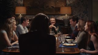 Colin Firth sits at the head of a family dinner table in The Staircase