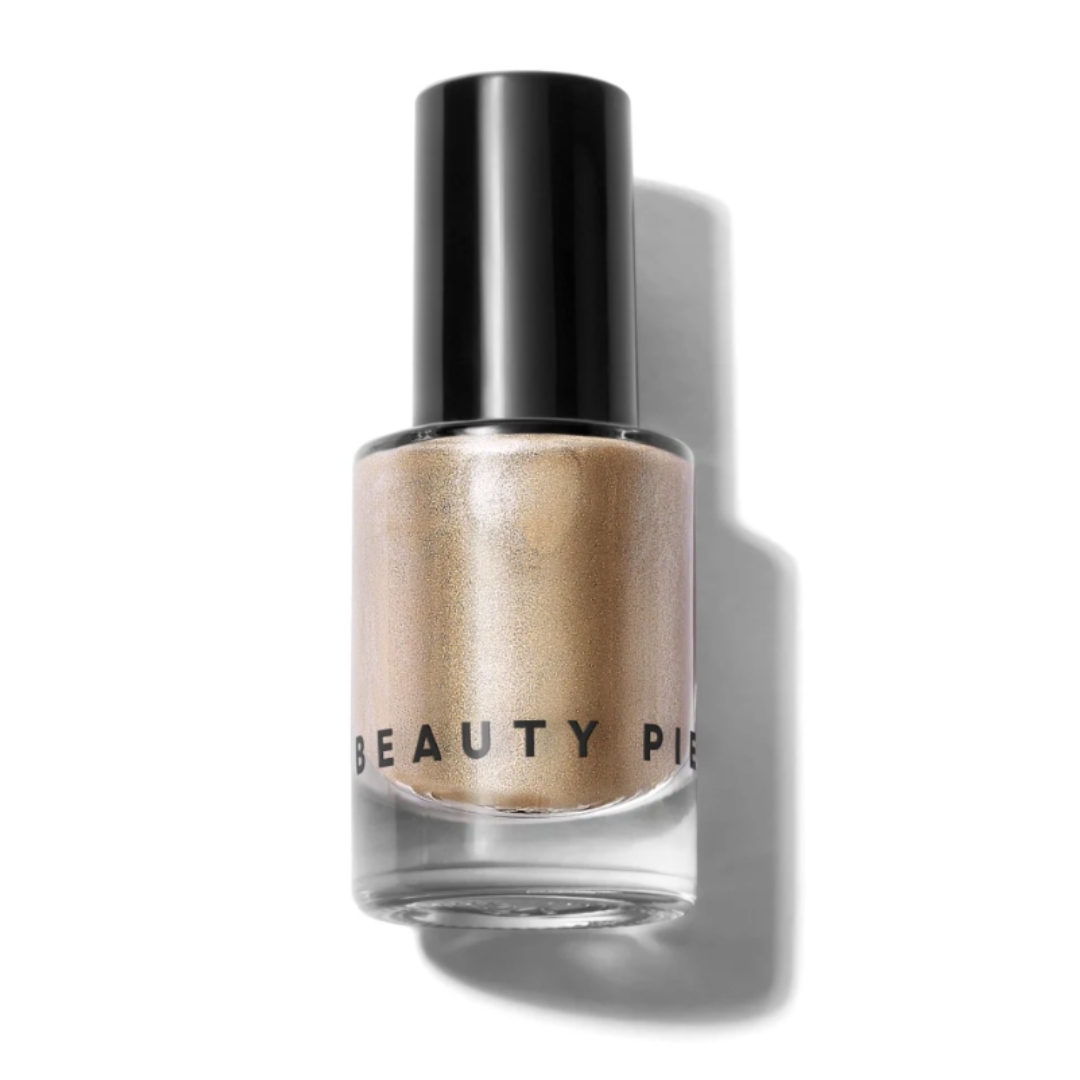 A product shot of the Beauty Pie Wondercolour nail polish in shade Gift Wrapped (a light, metallic gold), on a white background 