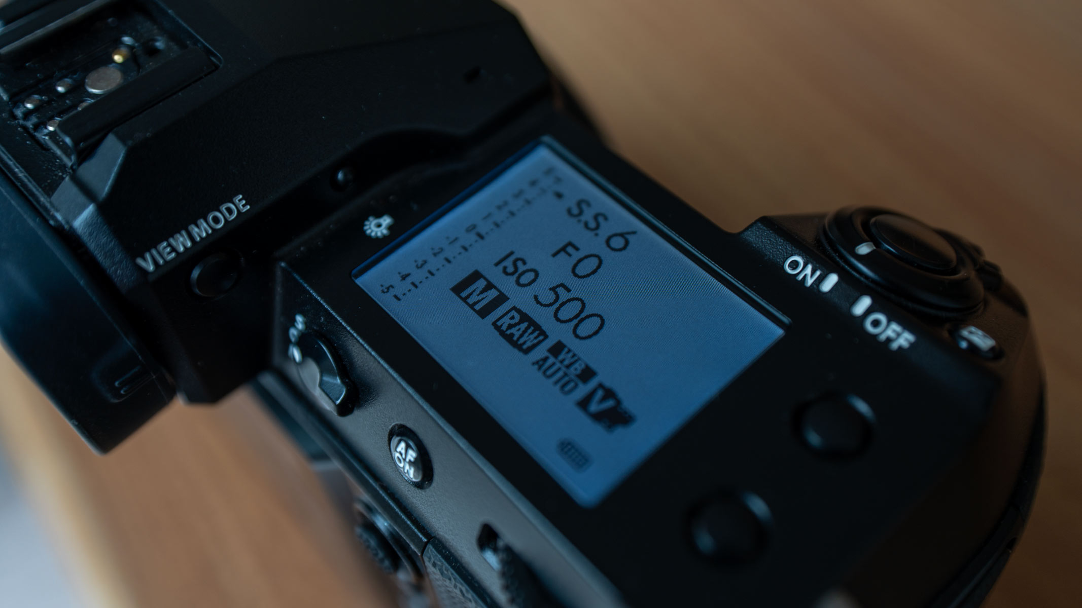 A close-up of the secondary LCD monitor with a white screen on the Fujifilm GFX100S II, showing exposure information.