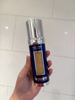 Mica Ricketts holding bottle of La Prairie Skin Caviar Liquid Lift