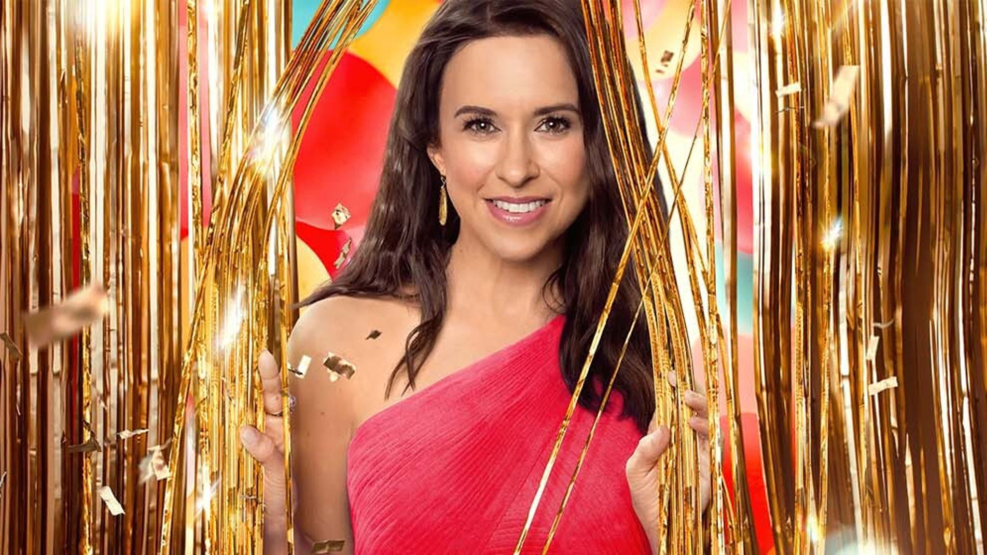 Lacey Chabert emerges from a gold glitter curtain