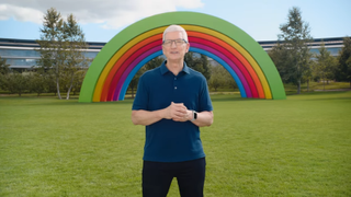 Tim Cook in front of a rainbow statue on the Apple campus