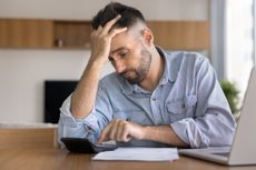 A stressed man calculating how much Making Tax Digital will cost him